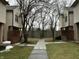 Exterior view of townhomes with sidewalk leading to a central courtyard and bare trees at 9452 Maple Way, Indianapolis, IN 46268