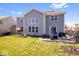 Spacious backyard with lush green lawn, patio seating, a play set, and a view of the home's exterior at 10155 Pepper Tree Ln, Noblesville, IN 46060