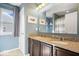 Bathroom featuring double sinks with granite counters, a large mirror, and neutral blue paint at 10155 Pepper Tree Ln, Noblesville, IN 46060