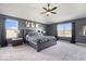 Serene main bedroom with neutral carpet, a ceiling fan, and large windows offering natural light at 10155 Pepper Tree Ln, Noblesville, IN 46060