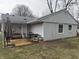 The back of the house with an outdoor patio set on a wooden deck and green backyard at 1016 Alden Dr, Fortville, IN 46040