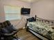 Cozy bedroom with a double bed, window, TV, rocking chair, and wood-look floors at 1016 Alden Dr, Fortville, IN 46040