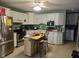 Kitchen featuring white cabinets, stainless steel appliances, a central island with chairs, with an adjacent laundry area at 1016 Alden Dr, Fortville, IN 46040