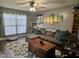 A comfortable living room features a sectional sofa, hardwood flooring, a coffee table, decorative wall art, and a cat tree at 1016 Alden Dr, Fortville, IN 46040