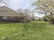 Lush backyard featuring shade trees and lawn surrounding a brick home with covered porch at 10343 Waveland Cir, Fishers, IN 46038