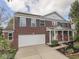 A beautiful brick two-story home with a two-car garage and a well-manicured front yard on a sunny day at 10343 Waveland Cir, Fishers, IN 46038