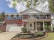 Charming red brick home featuring a welcoming front porch with white columns and a beautifully landscaped front yard at 10343 Waveland Cir, Fishers, IN 46038