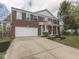 A beautiful brick two-story home with a two-car garage and a well-manicured front yard on a sunny day at 10343 Waveland Cir, Fishers, IN 46038