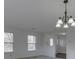 Bright living area with neutral colored carpet and white walls, illuminated by an elegant chandelier at 10343 Waveland Cir, Fishers, IN 46038