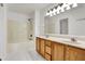 Bright bathroom with a double vanity, bathtub-shower combination, and white tiled floors at 1086 Meadowview Ct, Franklin, IN 46131