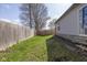A backyard featuring a wooden fence and green grass, providing a secure and private outdoor space at 10946 Snowdrop Way, Indianapolis, IN 46235