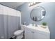 Well-lit bathroom with round mirror, white vanity, and combination shower and tub at 10946 Snowdrop Way, Indianapolis, IN 46235
