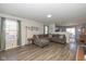 Inviting living room featuring hardwood floors, large sectional and access to dining area at 10946 Snowdrop Way, Indianapolis, IN 46235
