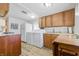Functional kitchen featuring wooden cabinets, white appliances, and in-unit washer and dryer at 1135 E Southern Ave, Indianapolis, IN 46203