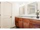 Well lit bathroom featuring a dual sink vanity, framed mirrors, and stone countertops at 12895 Grenville St, Carmel, IN 46032