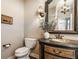 Charming powder room featuring an ornate vanity, decorative mirror, and unique lighting fixtures at 12895 Grenville St, Carmel, IN 46032