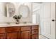 Bathroom featuring double sinks, framed mirrors, and dark wood cabinets at 12895 Grenville St, Carmel, IN 46032