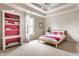 Bedroom with carpet, tray ceilings, bed, and custom shelves with pink accents at 12895 Grenville St, Carmel, IN 46032