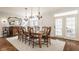 Bright dining room features a rustic wooden table with seating for eight and elegant chandelier lighting at 12895 Grenville St, Carmel, IN 46032