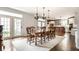 Spacious dining room with hardwood floors, French doors, chandelier lighting, and kitchen view at 12895 Grenville St, Carmel, IN 46032