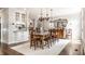 Elegant dining room featuring hardwood floors, chandelier lighting, and a dining table set for ten at 12895 Grenville St, Carmel, IN 46032