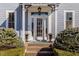 Front entrance with a glass door framed by sidelights, potted plants, and manicured bushes at 12895 Grenville St, Carmel, IN 46032