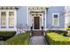 Inviting front porch of a blue two-story home with manicured lawn and brick walkway at 12895 Grenville St, Carmel, IN 46032