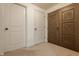 Hallway with multiple doors, including a unique carved wooden door, and neutral carpet at 12895 Grenville St, Carmel, IN 46032