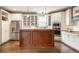 Bright kitchen featuring white cabinets, stainless steel appliances, a center island and hardwood floors at 12895 Grenville St, Carmel, IN 46032