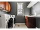 Laundry room with front load washer and dryer, wooden cabinets, and a sink at 12895 Grenville St, Carmel, IN 46032