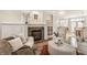 Bright living room boasting a fireplace, comfortable seating and view into the dining room and kitchen at 12895 Grenville St, Carmel, IN 46032