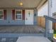 Close up of a well-maintained front porch with a wooden deck, offering a cozy outdoor space at 1327 E Minnesota St, Indianapolis, IN 46203