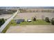 An aerial view showcases the home with a long driveway, garage, large yard and surrounding farmland at 1502 W 525 N, Lebanon, IN 46052