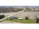 An aerial view features a gray home on a large lot and surrounding farmland with a nearby industrial construction site at 1502 W 525 N, Lebanon, IN 46052