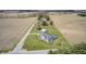 An aerial view showcases a charming house with long driveway, large yard, and surrounding farmland at 1502 W 525 N, Lebanon, IN 46052