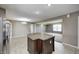 Open-concept kitchen with dark wood cabinets, stainless steel appliances, an island, and tile flooring at 1502 W 525 N, Lebanon, IN 46052