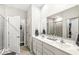 Bright bathroom featuring dual sinks with a large mirror and cabinet space at 17865 Haralson Row, Westfield, IN 46074
