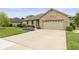 Charming brick home featuring a two-car garage, well-manicured lawn, and a long driveway at 1864 Holiday Pines Dr, Brownsburg, IN 46112