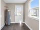Functional laundry room with a new water heater, door to the back yard, and natural light at 1924 S A St, Elwood, IN 46036