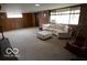Large carpeted basement with white sofas, fireplace, and big windows at 1936 Cunningham Rd, Indianapolis, IN 46224