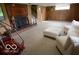 Carpeted basement with fireplace, hanging chair, and comfortable seating area at 1936 Cunningham Rd, Indianapolis, IN 46224