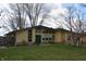 Ranch style home featuring a large front yard, big windows, and mature trees at 1936 Cunningham Rd, Indianapolis, IN 46224