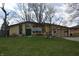 Inviting ranch home with green lawn, unique windows, and American flag at 1936 Cunningham Rd, Indianapolis, IN 46224