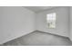 Bright bedroom featuring neutral carpet, a large window, and crisp white walls at 1952 White Oak Ln, Shelbyville, IN 46176