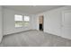 Neutral bedroom with a window overlooking the yard, adjacent bathroom and carpeted floor at 1952 White Oak Ln, Shelbyville, IN 46176