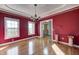 A red dining room showcases hardwood floors, tray ceilings and views to the front yard at 2009 W 250 N, Lebanon, IN 46052