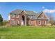 Beautiful two-story brick home with an arched entryway and a well-manicured lawn under a clear blue sky at 2009 W 250 N, Lebanon, IN 46052