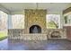 A cozy stone fireplace with storage alcove enhances the covered patio's ambiance and charm at 2009 W 250 N, Lebanon, IN 46052