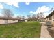 Expansive backyard featuring a well-maintained lawn and storage shed against a backdrop of a bright blue sky at 202 Rainbow Blvd, Indianapolis, IN 46234