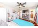 This bedroom has hardwood floors, a ceiling fan, a white dresser, and a flat screen TV on the wall at 202 Rainbow Blvd, Indianapolis, IN 46234